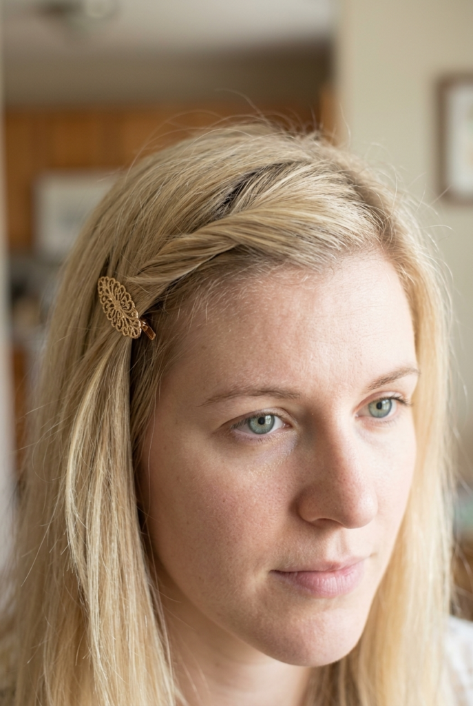 Woman with French bangs twisted and clipped back off her face