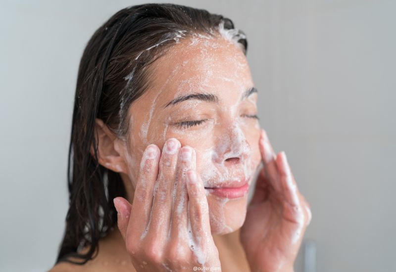 woman exfoliating skin in her shower